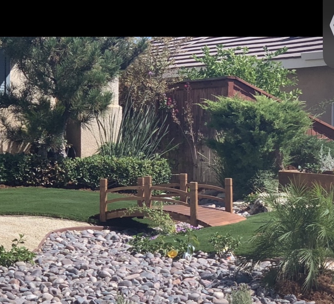 Front yard with decorative bridge, river rock, and drought-tolerant plantings in San Jacinto