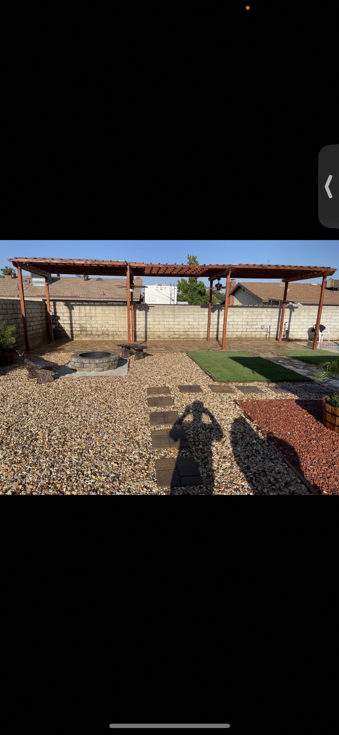 Pergola with fire pit, gravel yard, stepping stones, and turf section in San Jacinto