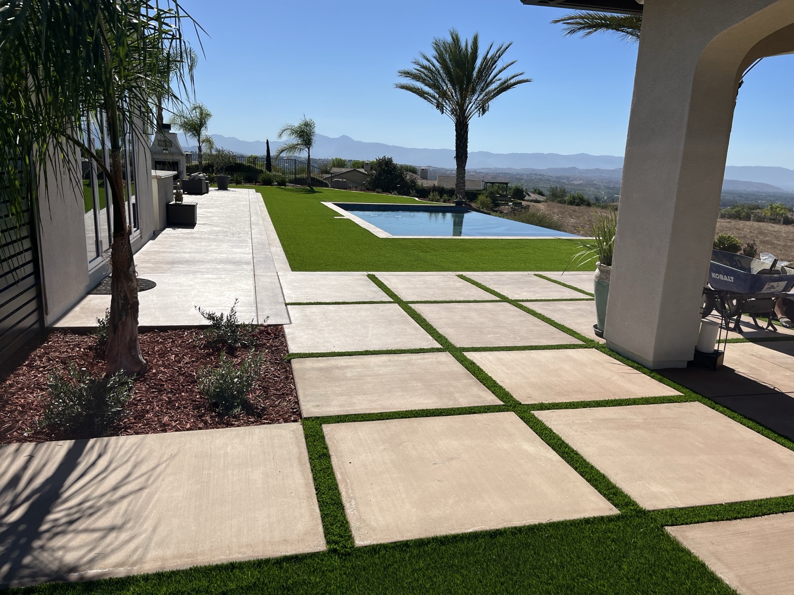 Premium artificial turf with concrete pavers and pool surrounded by mountain views in the Inland Empire