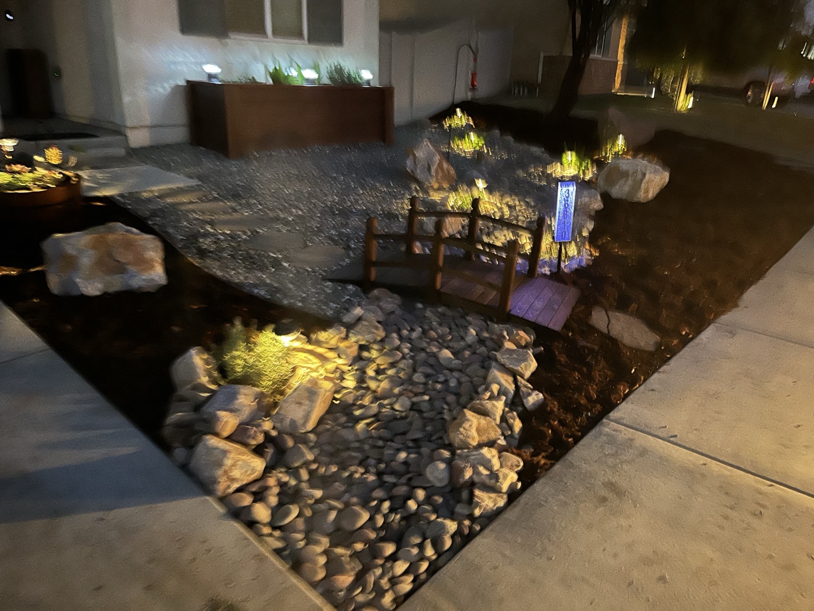Dramatic nighttime landscape with pathway lighting and rock features