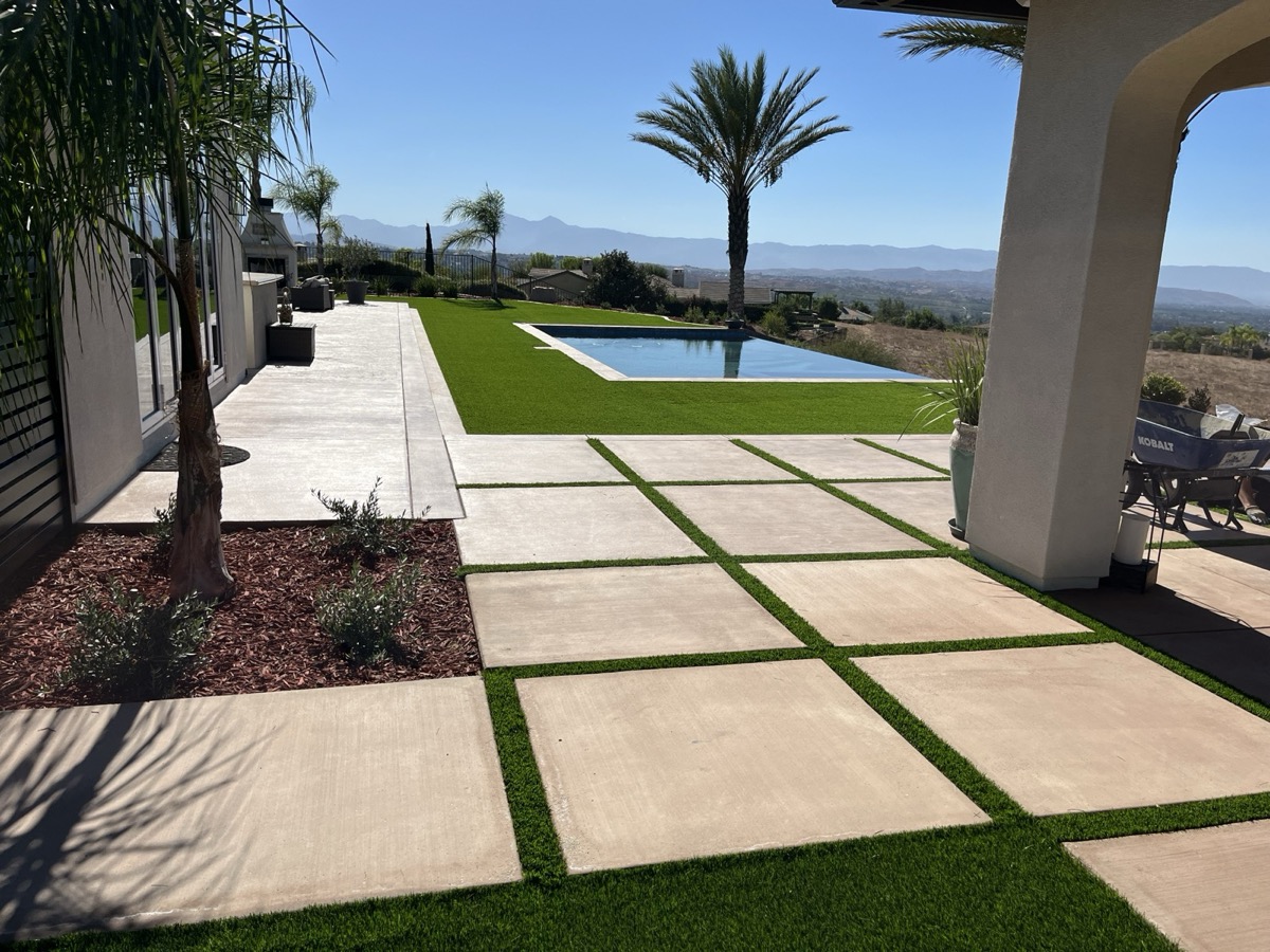 Freshly installed artificial turf backyard with pavers by SoCal Artificial Turfs in San Jacinto, CA